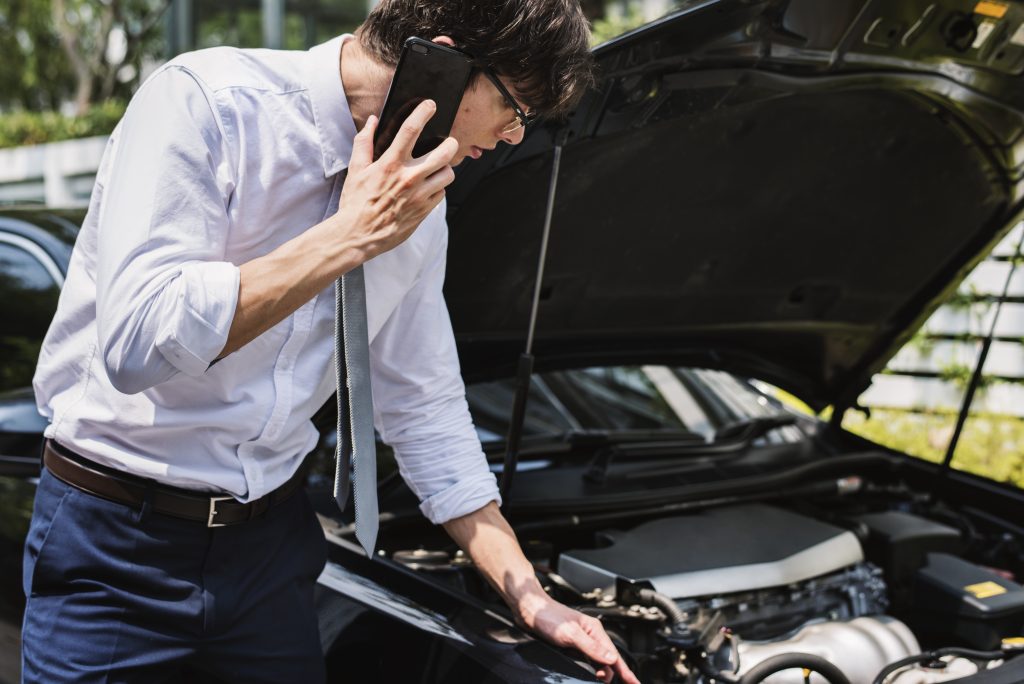 man calling help fix his car