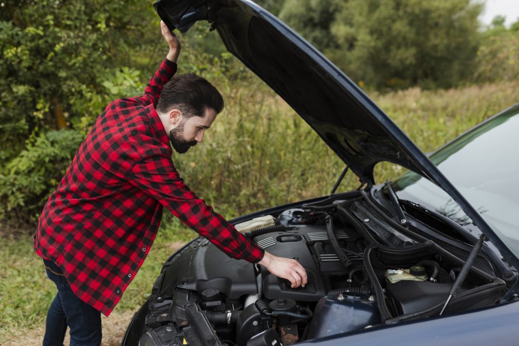 side view man checking engine